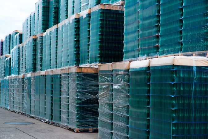 Several stacks of colorful beverage bottle crates outdoors.
